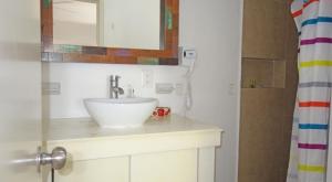 a bathroom with a white sink and a shower at El Fuerte Beach Apartments in Mahahual +55 photos