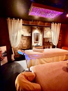 a bedroom with two beds and a purple light at La Terrasse Des Spas - Restaurant - Institut Massage in Hazebrouck