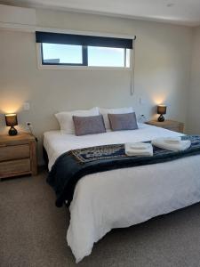 a bedroom with a large white bed with a window at Suncrest Villas in Cromwell