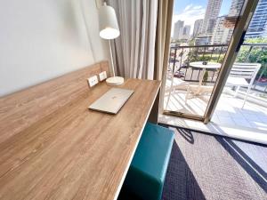 a wooden table with a laptop on it in a room with a balcony at Ocean View Suite 2 Beds Wi-Fi Netflix in Gold Coast