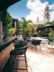 a patio with chairs and tables and a building at Piedra de Agua Hotel Boutique Mérida in Mérida