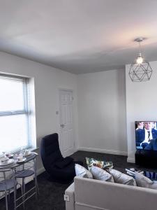 a living room with a couch and a table at Bright Housing in Newcastle upon Tyne