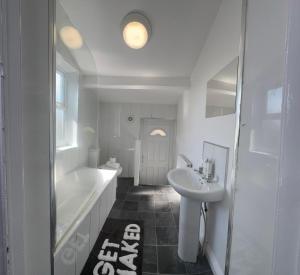 a white bathroom with a tub and a sink and a bath tub at Bright Housing in Newcastle upon Tyne +42 photos
