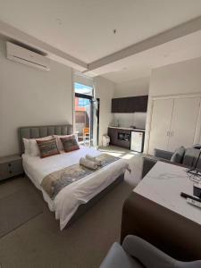 a bedroom with a large bed and a kitchen at Sixty Two On Grey Serviced Apartments in Melbourne