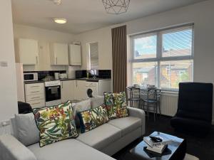 a living room with a couch and a kitchen at Bright Housing in Newcastle upon Tyne