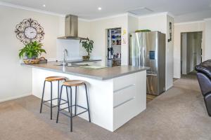 a kitchen with a refrigerator and two bar stools at The Bach in Coromandel Town