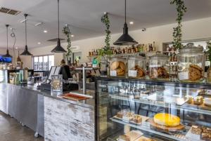 a bakery with a counter with a lot of pastries at Hotel Clipper in Rockingham