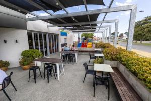 a patio with tables and chairs in a building at Hotel Clipper in Rockingham