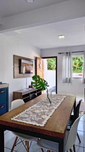 a dining room with a wooden table with a plant on it at Aconchego e Estilo em Brusque in Brusque