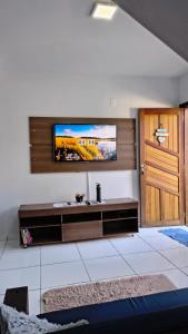 a living room with a flat screen tv on a wall at Aconchego e Estilo em Brusque in Brusque