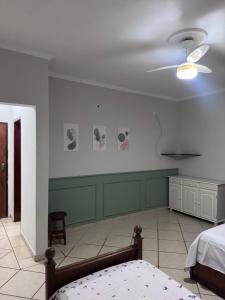 a bedroom with a bed and a ceiling fan at Quarto suíte privativo em campinas para até 3 pessoas in Campinas
