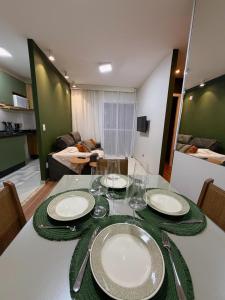 a dining room table with plates and wine glasses at Apartamento com academia - Toledo in Toledo