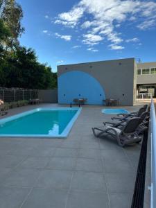 a swimming pool with lounge chairs next to a building at Apartamento com academia - Toledo in Toledo