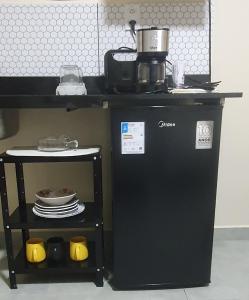 a small black refrigerator next to a counter with dishes at Studio Figueira, Sol in Santarém