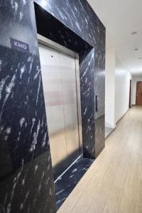 an elevator in an office building with a black wall at Hưng Phát Hotel Nghệ An in Vinh