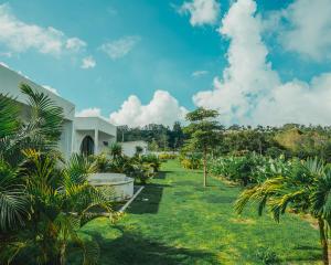 a garden with palm trees and a building at Hideout Kintamani and Hot Spring in Kintamani