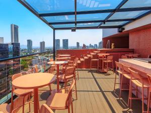 a restaurant with tables and chairs on a balcony at Brada Collection Stays in Guadalajara