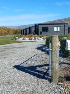 a house with a fence on the side of a gravel road at Suncrest Villas in Cromwell