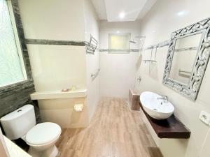 a white bathroom with a toilet and a sink at Bayside Bungalows in Candidasa +90 photos