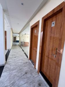 a hallway with two wooden doors in a building at Raman Resort Hotel and Banquet in Gagargārh