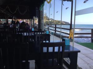 Aphrodite Beachfront Apartment في Ghaziveran: مطعم مع طاولة وكراسي والمحيط