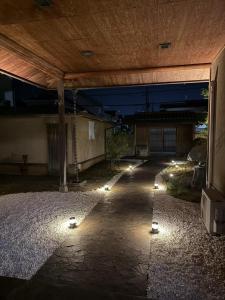 a patio with lights under a building at night at 红尘会馆 in Kishiwada