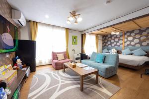 a living room with a couch and a bed at New 充実設備&コスパ&快適重視の宿!空港美瑛富良野スキー場4ヵ所アクセス良!キッズエリア大人気 in Asahikawa