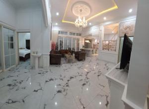 a living room with a chandelier and a white floor at Batu Villa Sakura in Batu +2 photos