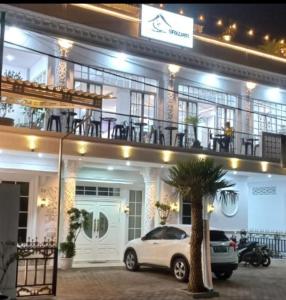 a white car parked in front of a building at Batu Villa Sakura in Batu