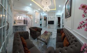 a living room with couches and a chandelier at Batu Villa Sakura in Batu