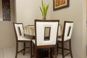a table with four chairs and a vase on top at Cozy Cottage in Woods +3 photos