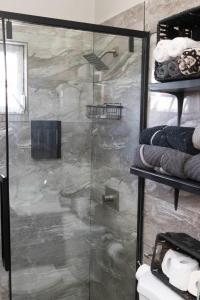 a bathroom with a shower with a glass door at Cozy Cottage in Woods