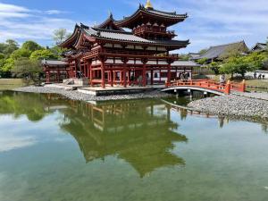 a building with a bridge over a body of water at サニーサイドホステル1号館 in Uji