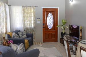 a living room with a blue couch and a wooden door at Cozy Cottage in Woods