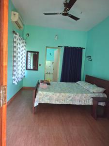 a bedroom with a bed and a ceiling fan at Kkheritage Homestay in Thottada