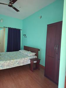 a bedroom with two beds and a closet and a door at Kkheritage Homestay in Thottada