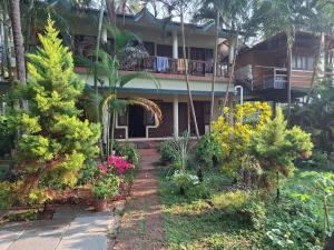 a house with trees and flowers in front of it at Kkheritage Homestay in Thottada