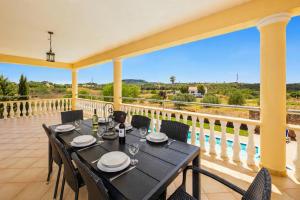 a dining table on the balcony of a house at Villa Entrecolinas in São Bartolomeu de Messines
