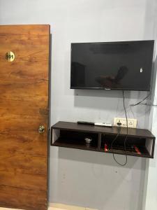 a flat screen tv hanging on a wall at The Human Stay in Indore