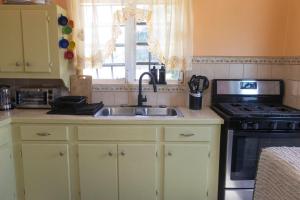 a kitchen with a sink and a stove at Cozy Cottage in Woods