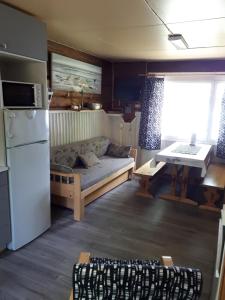 a living room with a couch and a table at Pääsky Schwalbe-cabin by crater lake in Varpaisjärvi