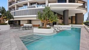 a building with a swimming pool in front of a building at Queens Wharf 1B plus Study apt - level 29 City view in Brisbane