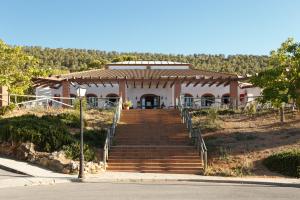 un edificio con una escalera que conduce a una casa en Camping la Sierrecilla en Humilladero