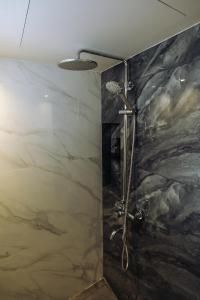 a shower in a bathroom with a black and white at Hotel Holm Bangkok in Bangkok