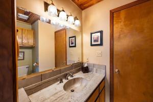 a bathroom with a sink and a large mirror at Charming 3-bedroom Angel Fire Cabin in Angel Fire