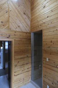 a bathroom with wooden walls and a walk in shower at Charming 3-bedroom Angel Fire Cabin in Angel Fire