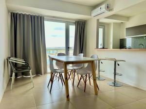 a dining room with a table and chairs and a window at Punta Flecha in Puerto Madryn +10 photos