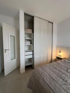 a bedroom with a closet and a bed and a door at Punta Flecha in Puerto Madryn