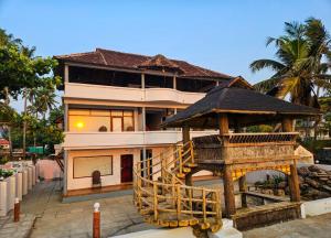 a large house with a staircase in front of it at Sea View Balcony room - Tide End Beach Villa in Pallipuram