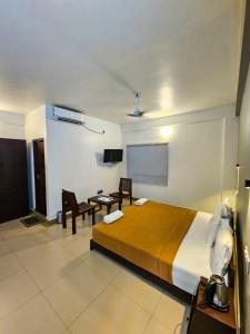 a hotel room with a bed and a table and chairs at Sea View Balcony room - Tide End Beach Villa in Pallipuram